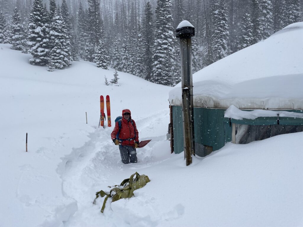 a man standing on top of a snow covered slope